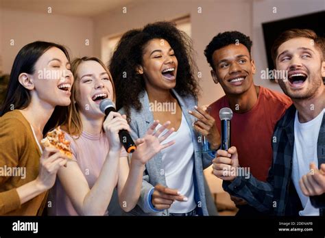 Sing It Enthusiastic Group Of Friends Singing With Microphone While Playing Karaoke At Home
