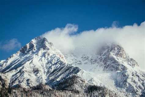Epic Snowy Mountain Peak With Clouds In Winter Landscape Alps