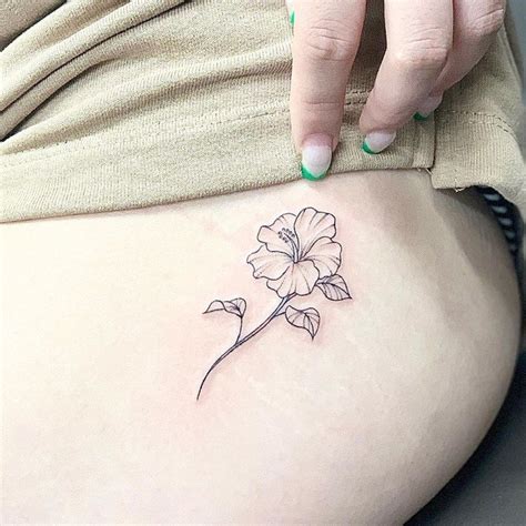 A Woman S Stomach With A Small Flower Tattoo On Her Lower Back Side Ribcage