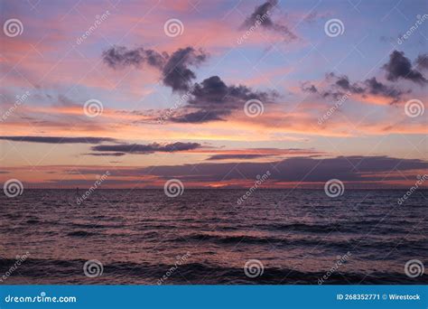 Beautiful Pink Sunset On The Seashore With A Cloudy Sky On The Horizon