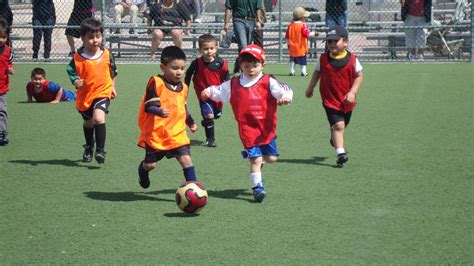 Niños jugando en el barrio de los suburbios. El fútbol en Bell, un deporte donde todos aprenden, juegan ...