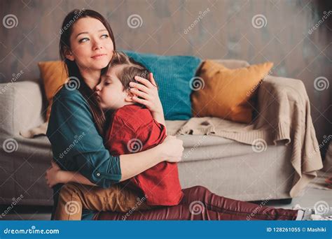 Indoor Portrait Of Happy Loving Mother Comforting Toddler Son At Home