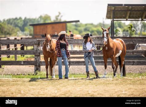 zwei junge cowgirls gehen im sommer mit ihren malpferden auf einer ranch stockfotografie alamy
