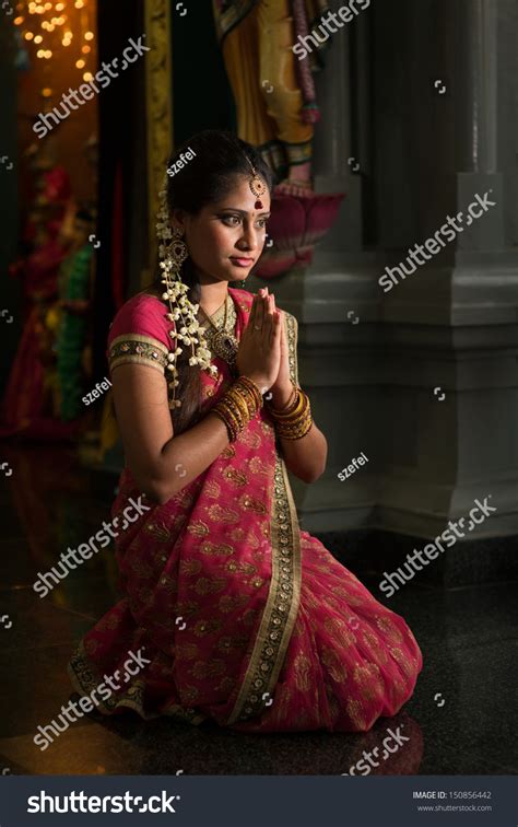 Young Indian Woman In Traditional Sari Dress Praying In A Hindu Temple