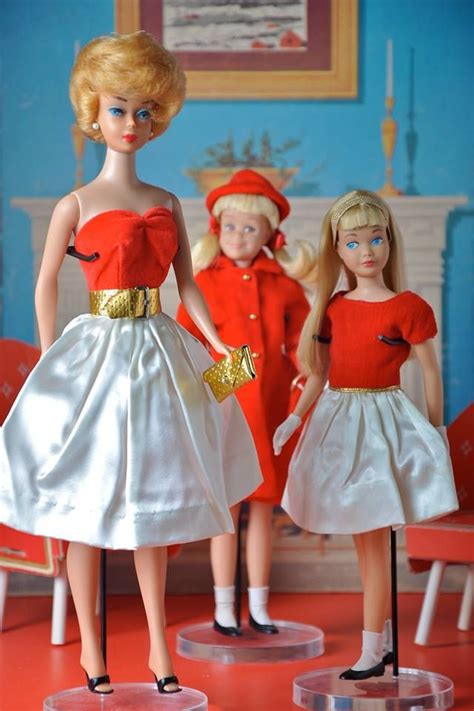 Two Dolls Standing Next To Each Other In Front Of A Red And White Room