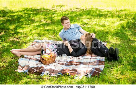Young Couple Kissing On Blanket At Picnic At Sunny Park Canstock