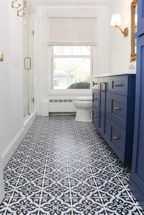 A Bathroom With Black And White Tile Flooring Next To A Blue Cabinetry