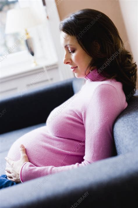 Pregnant Woman Sitting On Couch Stock Image F003 2187 Science Photo Library