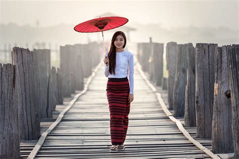 Woman In White Long Sleeved Shirt And Red Striped Skirt Holding