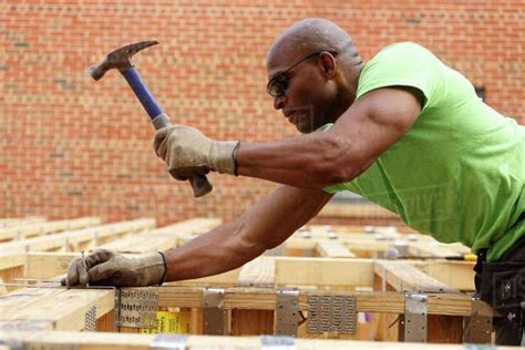 Black Man Hammering Nail At Construction Site Stock Photo Dissolve
