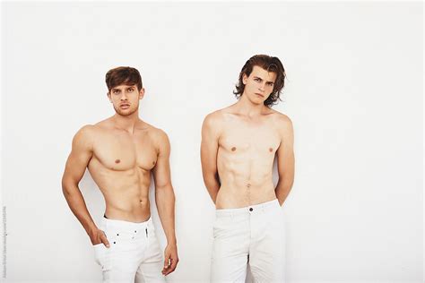 Two Male Models Posing Against White Wall By Stocksy Contributor