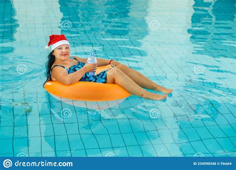 Jonge Brunette Vrouw In Santa Claus Hoed In Een Zwemcirkel In Het