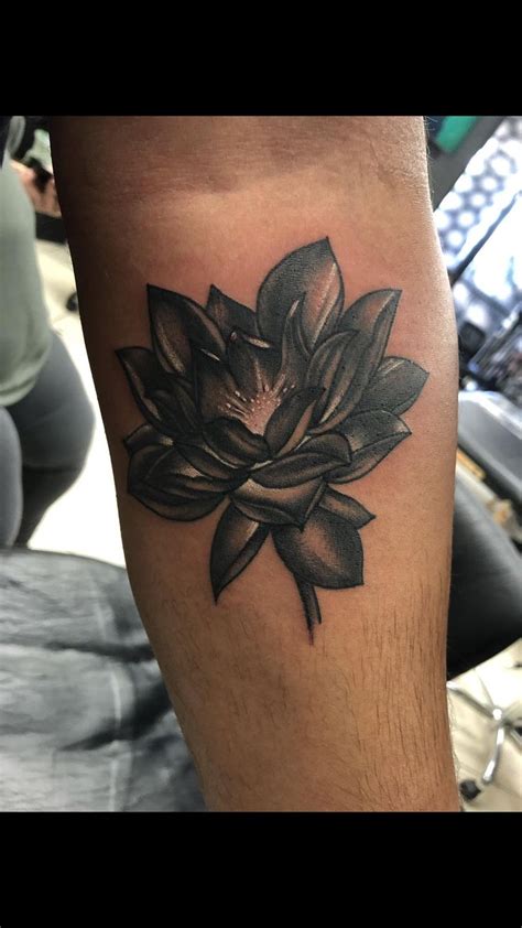 A Black And White Lotus Tattoo On The Leg