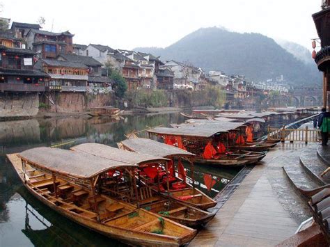 Several Wooden Boats Are Docked On The Water In Front Of Some Buildings