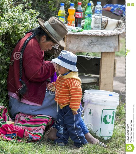 A Peruvian Lady And Her Son At A Drink Stall Next To The Inca Ruins Of