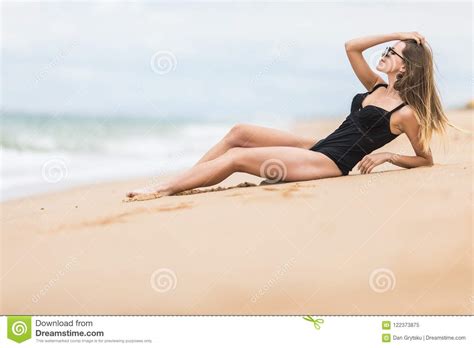 Beautiful Young Woman With Perfect Body Lying Down On The Beach Tanning On A Beach Resort