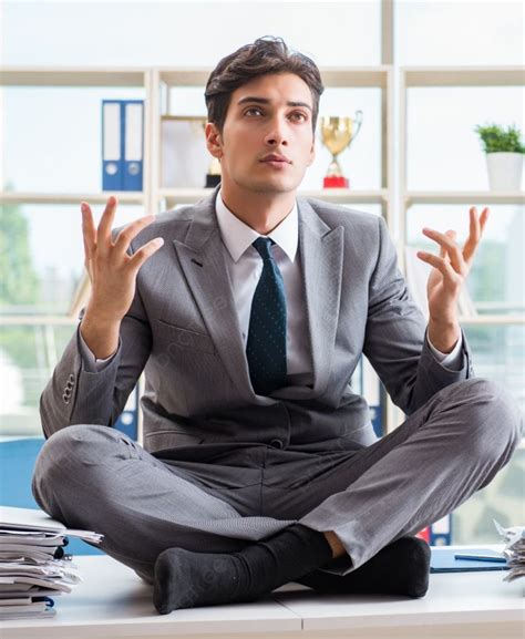 رجل أعمال يجلس على قمة المكتب في المكتب ، رجل أعمال يجلس على قمة المكتب