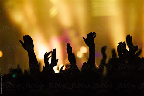 Hands In The Air Waving And Clapping At A Colourful Concert By