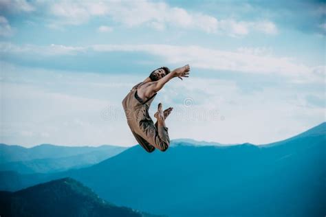 Cool Looking Dancer Makes A Difficult Jump Against Blue Sky Stock Image