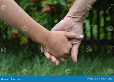 Granddaughter And Grandmother Holding Hands Outdoors Close Up Stock