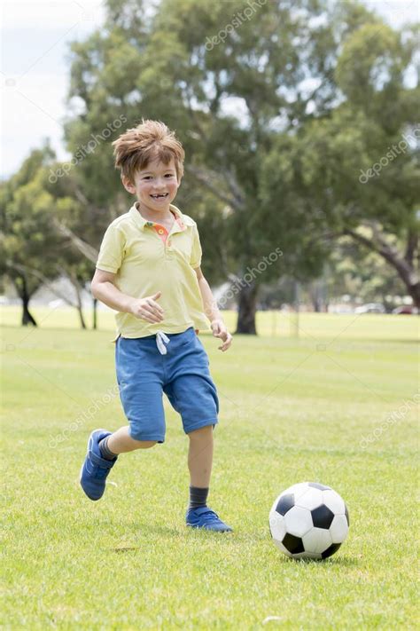 Vectores e ilustraciones de stock sin royalties de niño jugando futbol. Niño 7 o 8 años disfrutando feliz jugando fútbol en el campo del parque de la ciudad de pasto ...