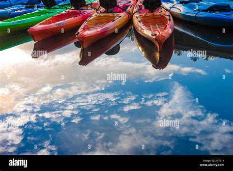 Colorful Kayaks And Sunlit Clouds Reflect In The Glassy Lake At Vogel