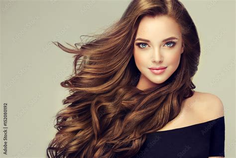 Brunette Girl With Long And Shiny Wavy Hair Beautiful Model With Curly Hairstyle Stock Photo