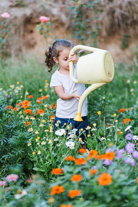 Child Watering Flowers By Stocksy Contributor Dejan Ristovski Stocksy