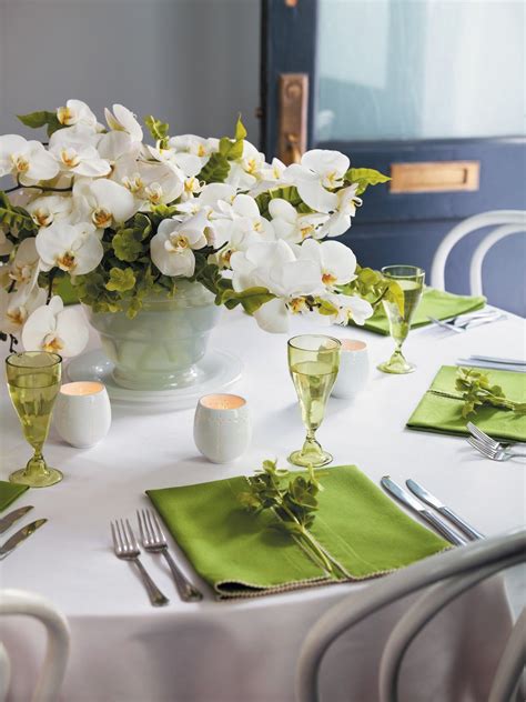 For a long dining room table, three mason jars filled with daffodils is beautiful. lush orchid centerpiece | beautiful green and white ...