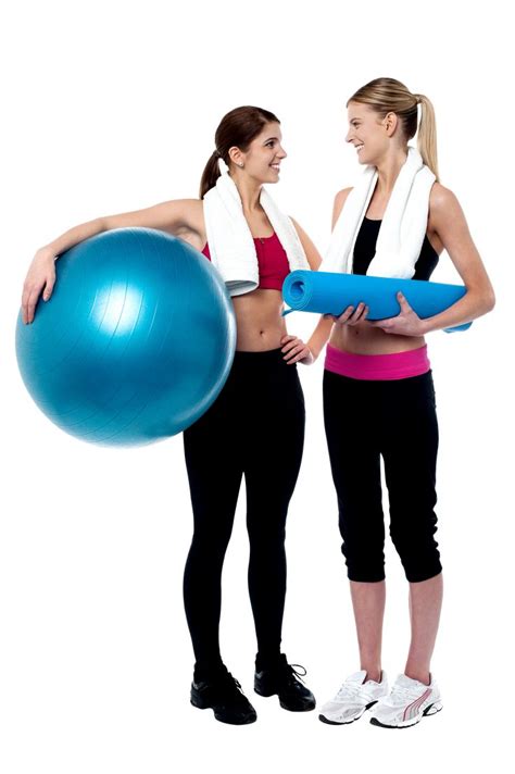 Two Women Standing Next To Each Other Holding An Exercise Ball