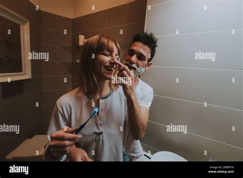 couple morning routine man and woman sharing bathroom shaving beard and brushing teeth stock
