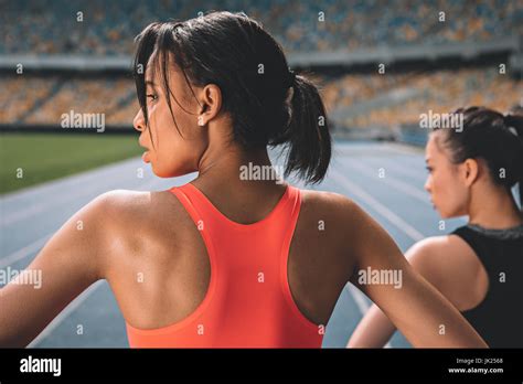 Athletic Young Women In Sportswear Exercising On Running Track Stadium