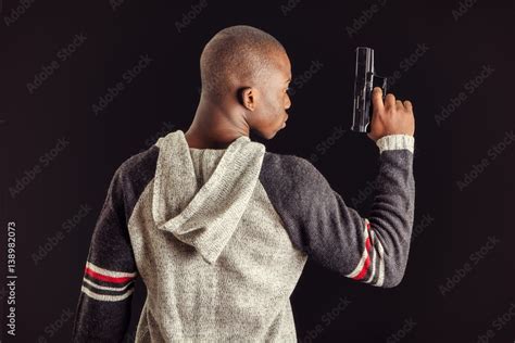 Young Handsome Black Man Holding A Hand Gun On Dark Background In