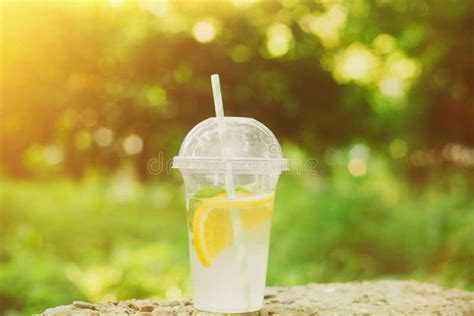 Summer Drink Lemonade With Orange And Mint In The Plastic Cup Against