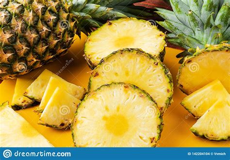 Fresh Ripe Tropical Pineapple Cut Into Slices On A Yellow Rackside