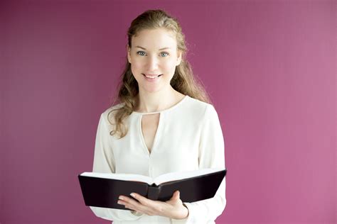 Smiling Young Beautiful Female Teacher With Book enseignant - Formations&Co