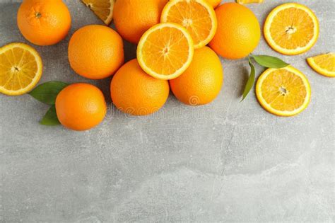 Many Ripe Oranges And Leaves With Space For Text On Grey Table Stock
