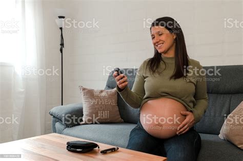Pregnant Latina Woman Looking At Her Glucose Test Result And Smiling