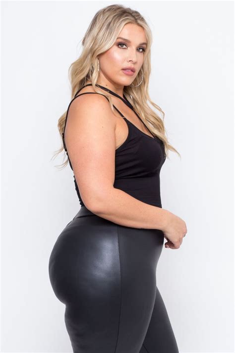 A Woman In Black Leather Leggings With Her Hands On Her Hips Posing