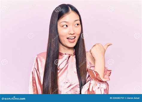 Young Beautiful Chinese Woman Wearing Casual Shirt Pointing Thumb Up To
