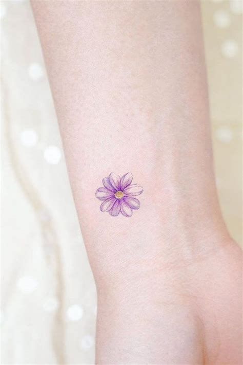 A Small Purple Flower Tattoo On The Left Side Of The Ankle With White