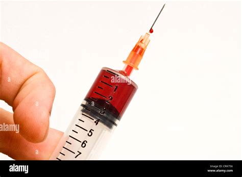 View Of A Needle Attached To A Syringe Filled With Blood Stock Photo