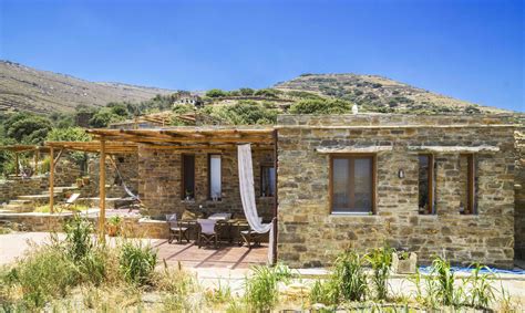 A fancy stone house with a spacious built its unique windows highlight the overall appearance of the house. The big stone house - Tinos Eco Lodge