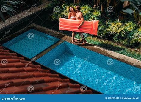 Couple Having Fun At The Swimming Pool The Couple Is Relaxing By The