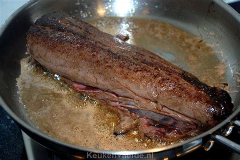 A Large Piece Of Meat Cooking In A Pan On The Stove