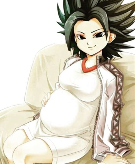 A Pregnant Woman Sitting On Top Of A Couch Next To A White Chair With Black Hair