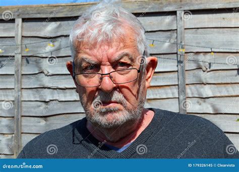 Senior Man Wearing Spectacles Glaring Towards Camera Stock Image