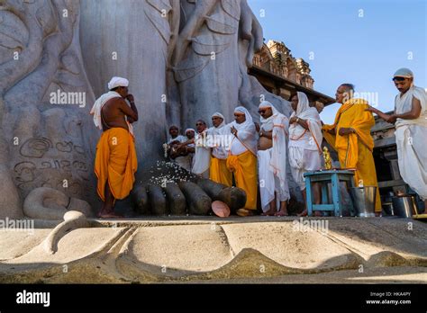 A Group Of Jain Pilgrims Is Praying At The Feet Of Gomateshwara The