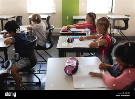 Kids Studying In Classroom Sitting At Desks In School Stock Photo Alamy