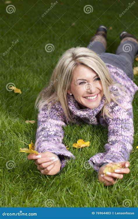 attractive matured woman lying in the autumn grass stock image image of plus relax 76964483